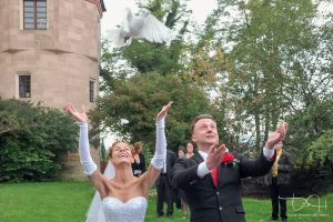 Das Brautpaar lässt weiße Tauben steigen - der Hochzeitsfotograf
