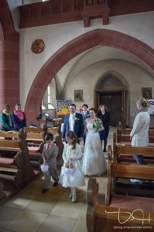Das Brautpaar zieht in die Kirche ein. Der Hochzeits Fotograf fotografiert das Brautpaar.
