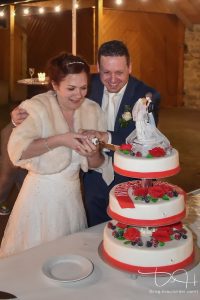 Wer hat die Hand beim Anschneiden der Torte oben? Euer Hochzeitsfotograf macht das Beweisfoto! Hochzeitsfeier im Gasthaus Englert.